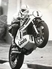 Stu Avant lifting the front wheel of a Levis-sponsored Yamaha, number 1, in a black and white photo