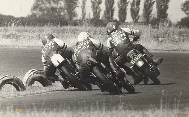 Mike Sinclair, Stu Avant and John Boote racing through a corner in a 1970s black and white photo