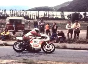John Boote racing a Yamaha TZ750, number 140, past spectators on a roadside circuit